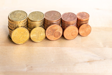 Mehrere Stapel mit EURO-Münzen zeugen von fleißigem Sparen und dem Ersparten eines Kindes