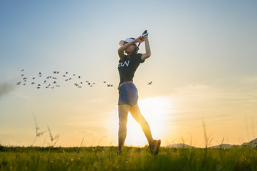 woman golf player in action setup after hit the golf ball away from fairway to the destination...