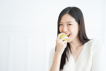 Young Asian woman bite green apple show Strong teeth