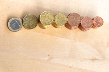 Mehrere Stapel mit EURO-Münzen zeugen von fleißigem Sparen und dem Ersparten eines Kindes