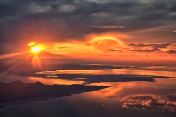 Fototapeta na wymiar Great Salt Lake Sunset Aerial view from airplane in Wasatch Rocky Mountain Range, sweeping cloudscape and landscape during day time in Spring. In Utah, United States.