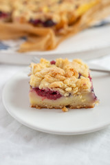 crumble cake in a baking form and pieces of the cake on a table