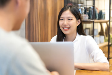 Young Asian woman sitting in cafe talking and having a meeting.