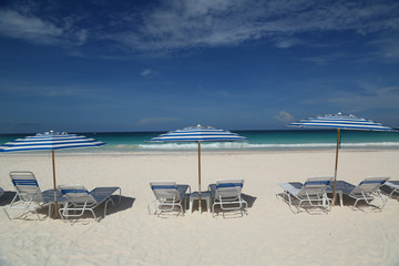 Beach chairs and umbrella on a beautiful Caribbean beach at Harbor Island, Bahamas
