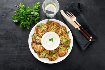 Zucchini fritters or pancakes with yogurt dressing with fresh herbs.