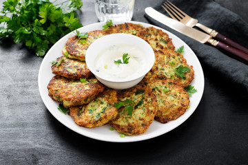 Zucchini fritters or pancakes with yogurt dressing with fresh herbs.