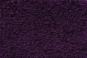 Dark purple fluffy background of soft, fleecy cloth. Texture of textile closeup