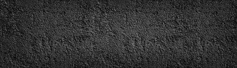 Black painted stone wall wide texture. Dark coarse pebbledash panoramic background