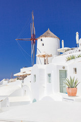 beautiful Oia town on Santorini island, Greece. Traditional white architecture and greek orthodox churches with blue domes over the Caldera, Aegean sea. Scenic travel background