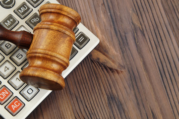 Wooden judge gavel and calculator on wooden background, law and arbitration concept