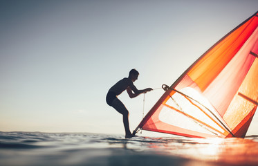 Silhouette of windsurfer uplift windsurf board sail. Windsurfing, sailing, surfing, water sports