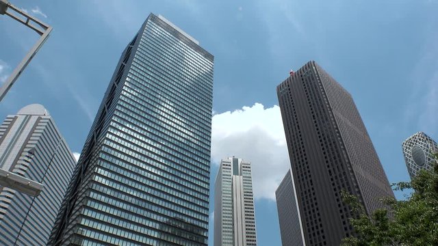 SHINJUKU, TOKYO, JAPAN : View of looking up tall modern buildings and sky in day time. Famous business district in Tokyo, where many company office buildings are located.