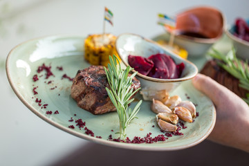 grilled sliced steak and rosemary on plate. serving dishes in the restaurant