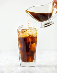 coffee pouring into glass of ice