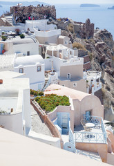 beautiful Oia town on Santorini island, Greece. Traditional white architecture and greek orthodox churches with blue domes over the Caldera, Aegean sea. Scenic travel background