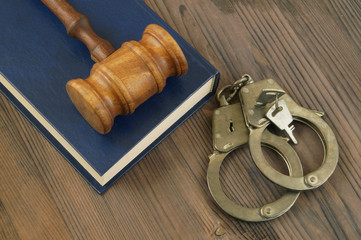 Gavel on book and handcuffs with keys
