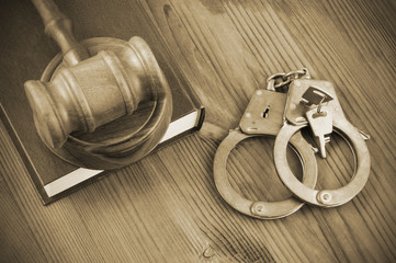 Legal book, wooden judge gavel and handcuffs with keys on table, crime and law concept