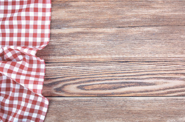 Red checked picnic towel cloth on wooden empty space background.
