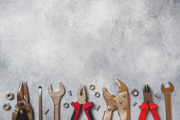 Pliers, screwdrivers and wrench combination on grey concrete background with copy space....