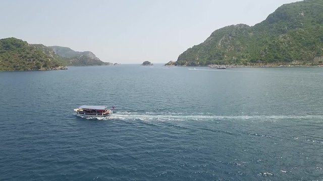 Aerial view: sightseeing boat with tourists sailing on Marmaris Turkey with clear turquoise water