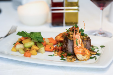 Scampi an Steak Fleisch auf weißem Teller mit Gemüse