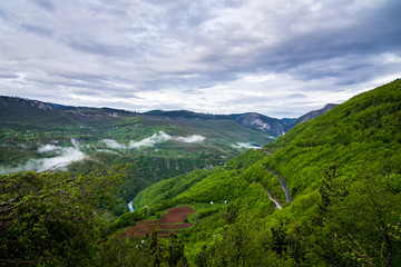 Fototapeta na wymiar Montenegro, Impressive view over green wooded rocks of famous tara canyon nature landscape formed by tara river from above