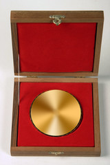 Award or souvenir made of brass metal in a wooden box covered with red velvet.
