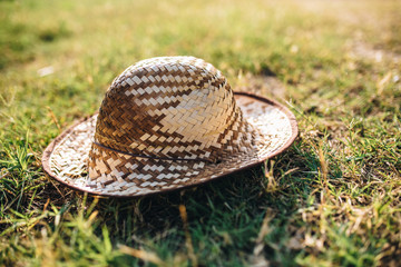 Summer sun hat made from straw on the ground. Green grass grond. Summer concept
