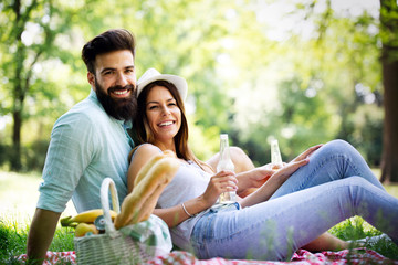 Happy young couple enjoying picnic in park.