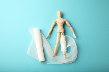 Figure of man with leg wound and white gauze bandage. First aid, injury treatment. Patient in hospital.