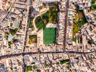 Football field surrounded by stone city. Turkey Malta. Aerial top view