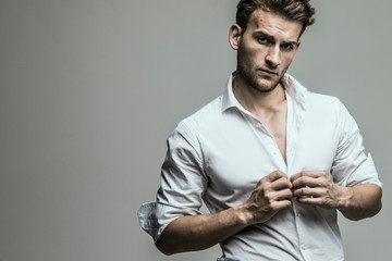 Portrait of young and handsome model in a white shirt. Studio shot. Copy space.