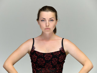 Fototapeta premium Closeup portrait of pretty girl, brunette woman 30 years old on a light gray background with beautiful dark hair and excellent skin of the face and body. She shows emotions, smiles, wonders.