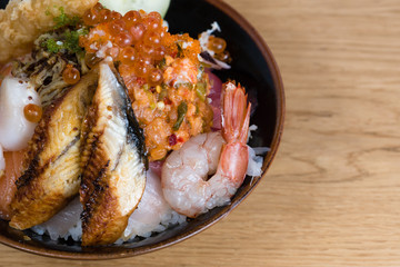 typical Japanese fish donburi, shrimp tempura, raw shrimps, salmon fillets, grilled tuna, caviar, tuna tartare, sliced cucumbers, raw sea bass fillets, omelette and different types of caviar