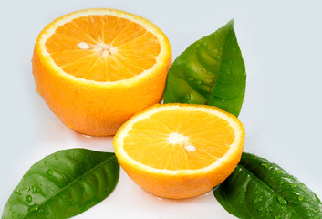 Freshly cut orange with leaves under the tap