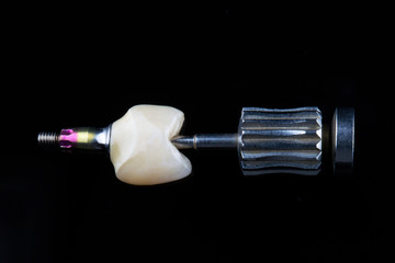 high-quality ceramic dental crown on black glass