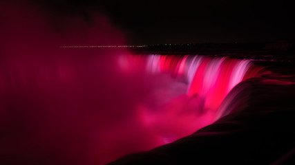 Niagara Falls is illuminated in glowing red colours