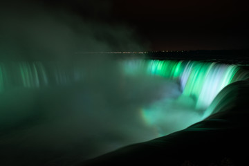 Niagara Falls illuminated in glowing green colours