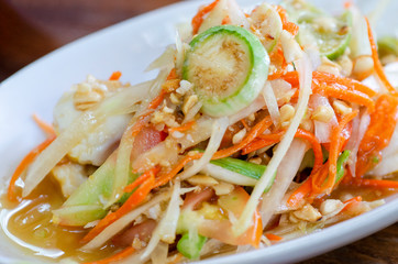 Thai food, papaya salad in a white dish with a blurred background