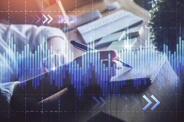 Financial forex charts displayed on woman's hand taking notes background. Concept of research. Double exposure