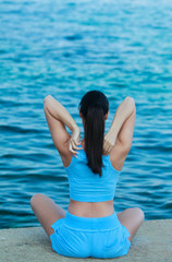 Jeune femme faisant son Yoga face à la mer