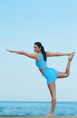 Jeune femme faisant son Yoga face à la mer
