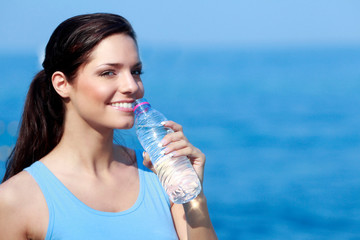Jeune femme buvant de l'eau pendant son sport