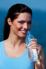 Jeune femme buvant de l'eau pendant son sport