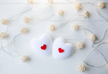 Red and white hearts on wooden background. Saint Valentine's day concept. Love and romantic photo. Postcard for holiday. Small rustic lights.