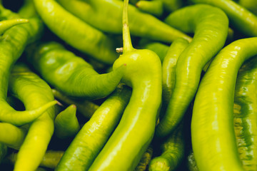 Green vegetables. Organic long green peppers on wooden background, selective focus, horizontal