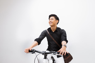 Stylish handsome young man with bicycle looking away isolated on white