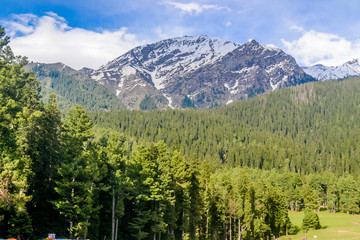 Beautiful view of Pahalgam, known as ‘Valley of Shepherds’ of Kashmir valley (Paradise on Earth) surrounded by snow frozen Himalayas glacier mountains and green fir and pine tree line forest landscape