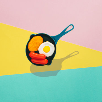 Breakfast in a pan flies over a colored background with strong shadows. The concept of minimalism.