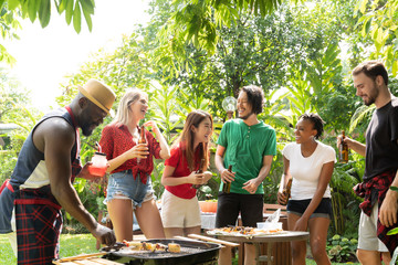 Group of people toasting beers celebration and having barbecue party outdoors garden
